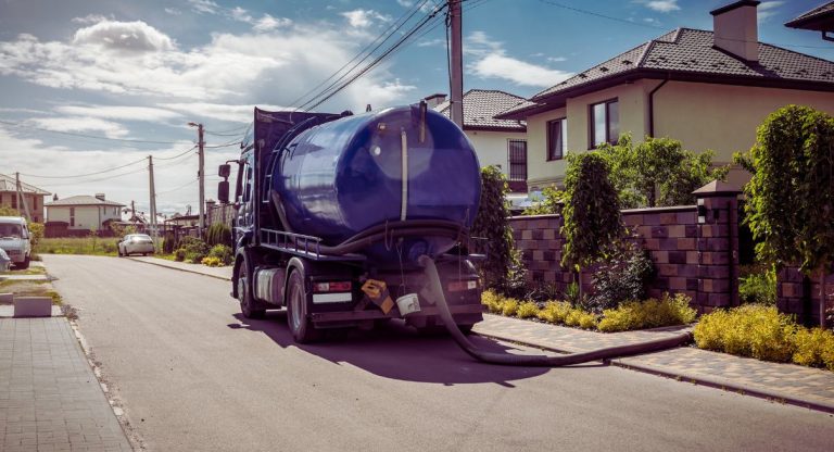 Camion de pompage vidangeant une fosse septique dans une rue residentielle