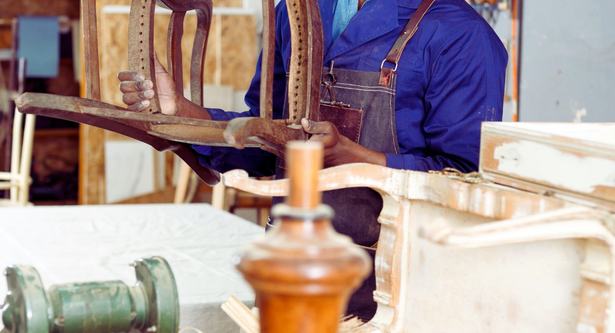 Restaurateur de meubles renovant une chaise ancienne en atelier