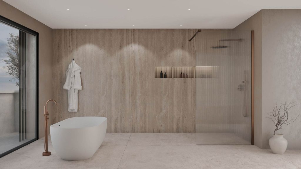 Salle de bain en travertin beige avec baignoire îlot et robinetterie en cuivre face à une baie vitrée
