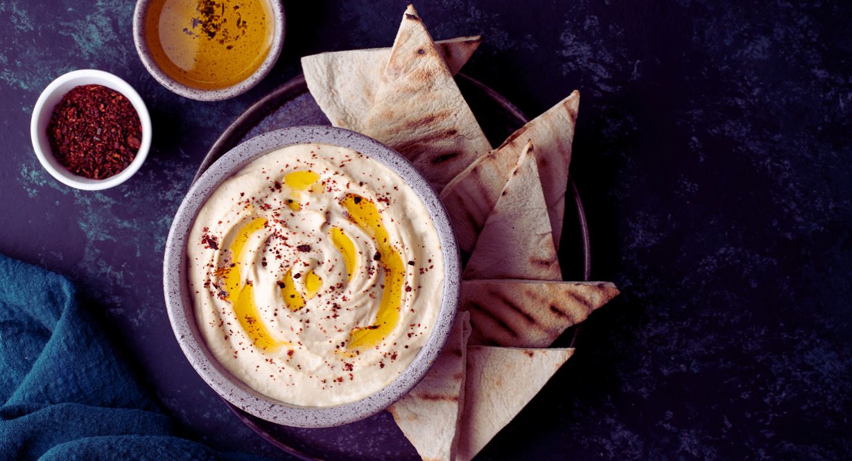 Bol de houmous avec triangles de pain pita et épices