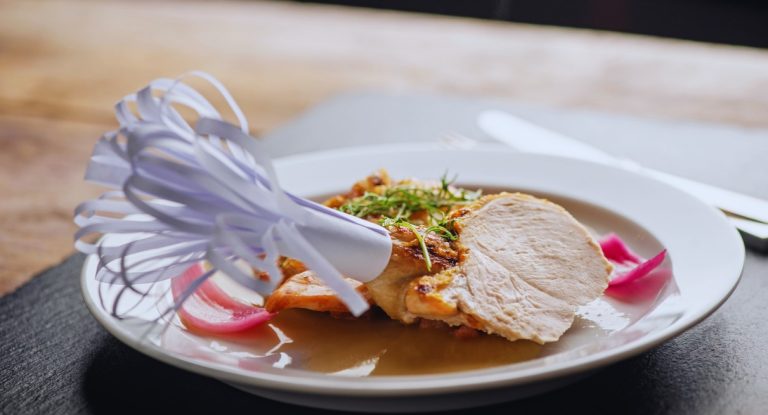 Volaille rotie tranchee et dressee sur assiette blanche