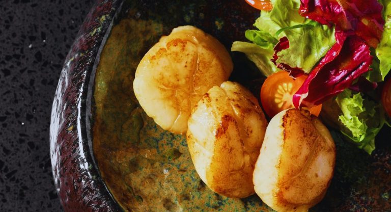 Coquilles Saint-Jacques poêlées servies avec une salade fraîche
