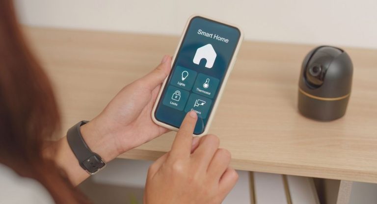 Une personne pilote l'éclairage et le thermostat de son logement depuis une application mobile